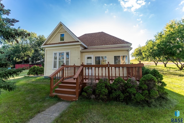 back of property featuring a lawn and a deck