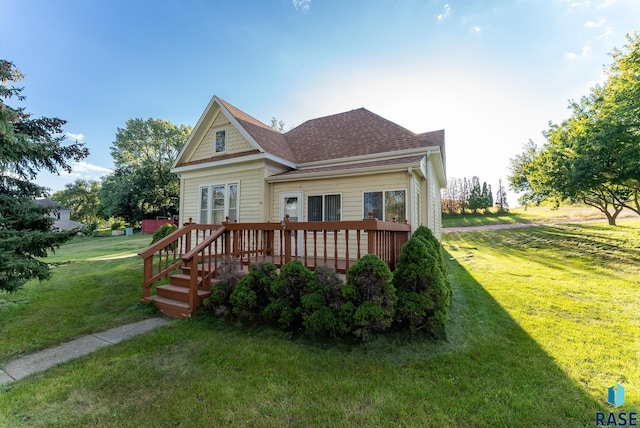 rear view of house with a lawn and a deck