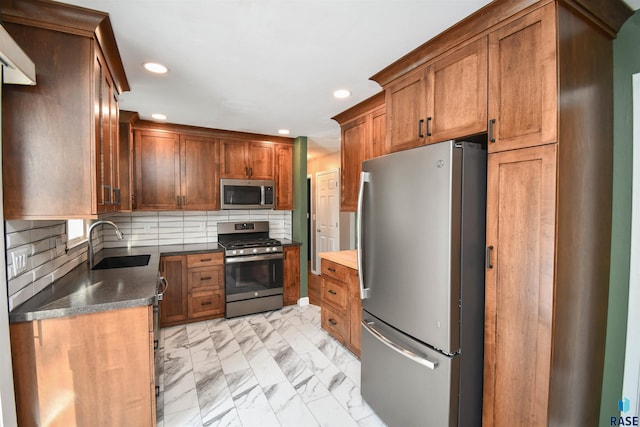 kitchen featuring stainless steel appliances, tasteful backsplash, dark stone countertops, and sink