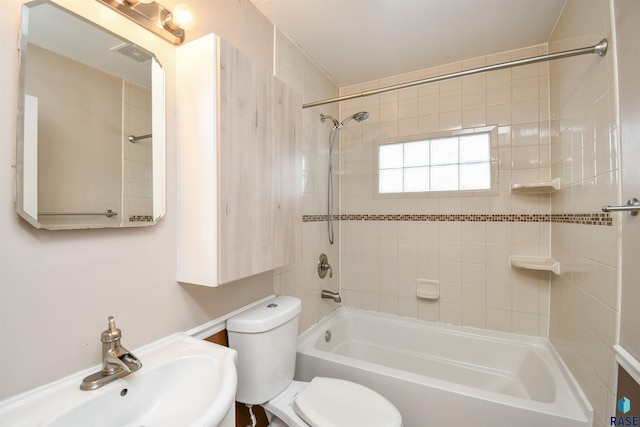 full bathroom featuring toilet, sink, and tiled shower / bath