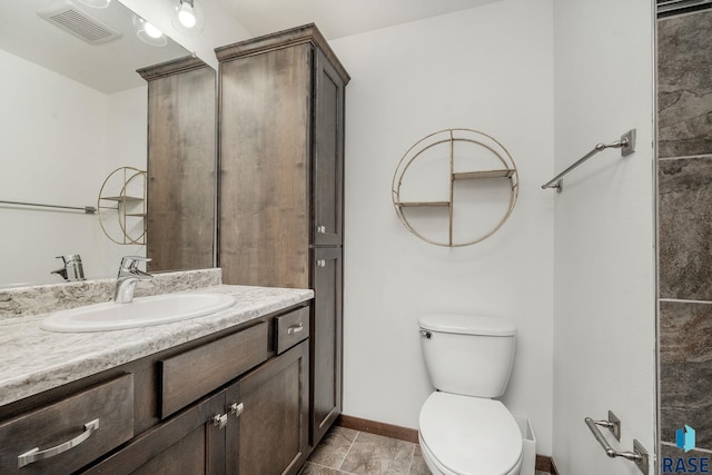 bathroom featuring tile patterned flooring, vanity, and toilet