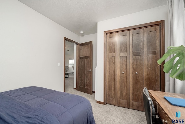 carpeted bedroom featuring a textured ceiling and a closet