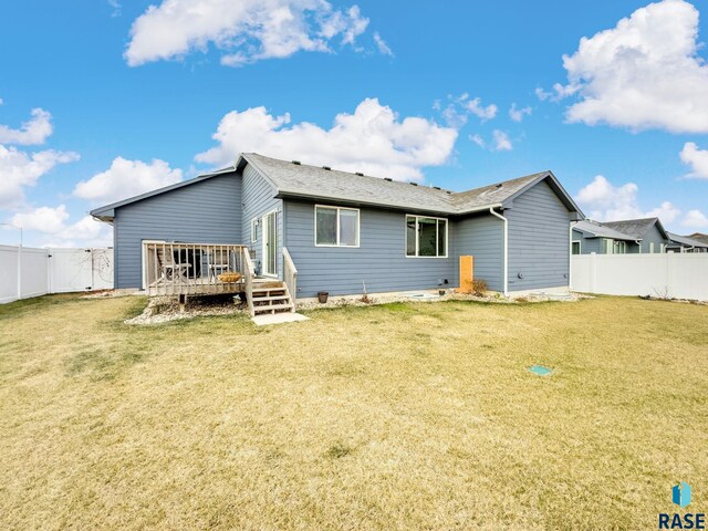 rear view of property with a yard and a deck