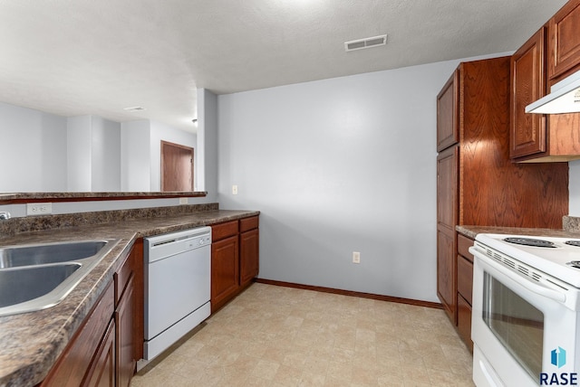 kitchen featuring a textured ceiling, white appliances, and sink