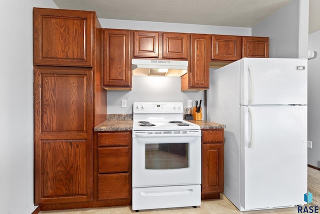 kitchen featuring light stone counters, white appliances, and a textured ceiling