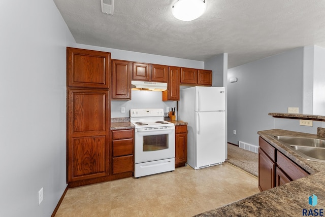 kitchen with a textured ceiling, white appliances, and sink