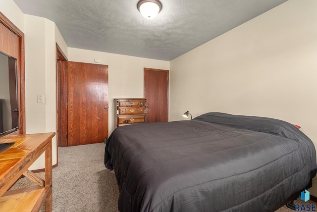 bedroom featuring light carpet and a textured ceiling