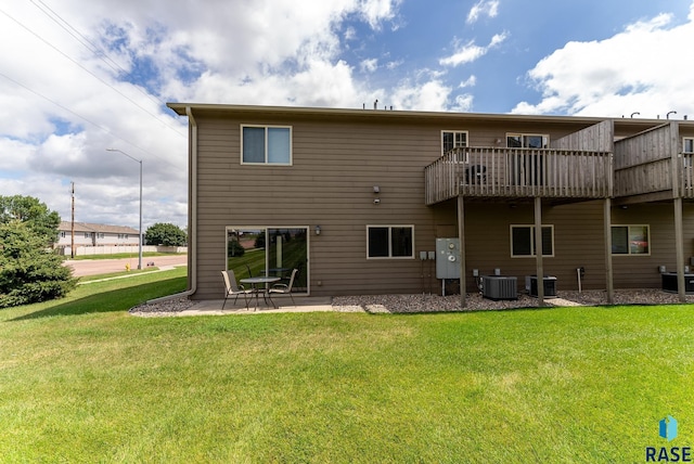 back of house featuring a patio, a balcony, central AC unit, and a lawn