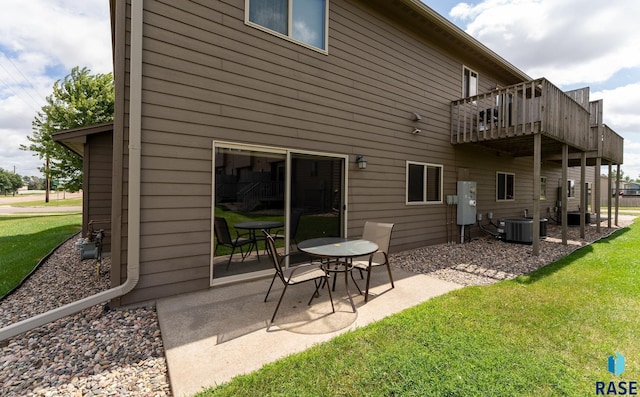 back of house with a balcony, cooling unit, a patio area, and a lawn