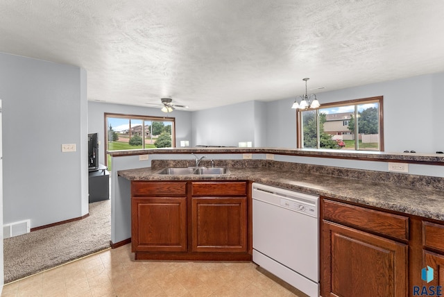 kitchen with sink, white dishwasher, a healthy amount of sunlight, and a textured ceiling