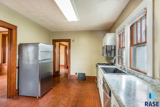 kitchen featuring sink, dark hardwood / wood-style flooring, white cabinetry, and stainless steel appliances