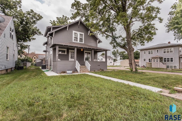 view of front of property with covered porch, central AC, and a front yard