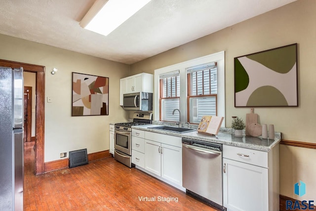 kitchen featuring dark hardwood / wood-style flooring, stainless steel appliances, white cabinetry, and sink