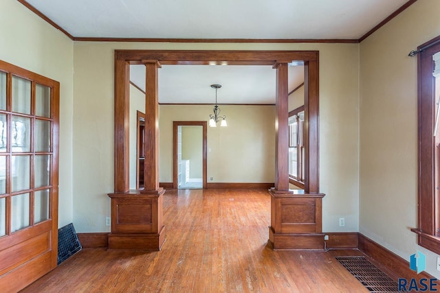 interior space featuring hardwood / wood-style floors, a notable chandelier, and ornamental molding