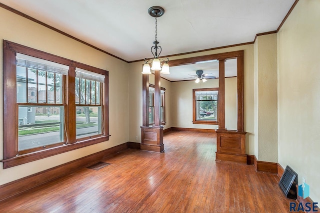 unfurnished dining area featuring dark hardwood / wood-style flooring, ceiling fan, and crown molding