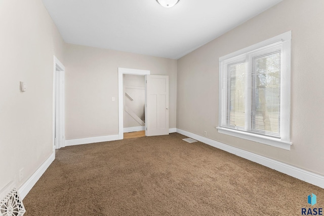 unfurnished bedroom featuring a closet, carpet floors, and multiple windows