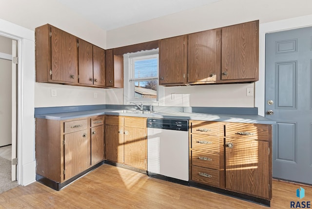 kitchen with white dishwasher, light hardwood / wood-style floors, and sink