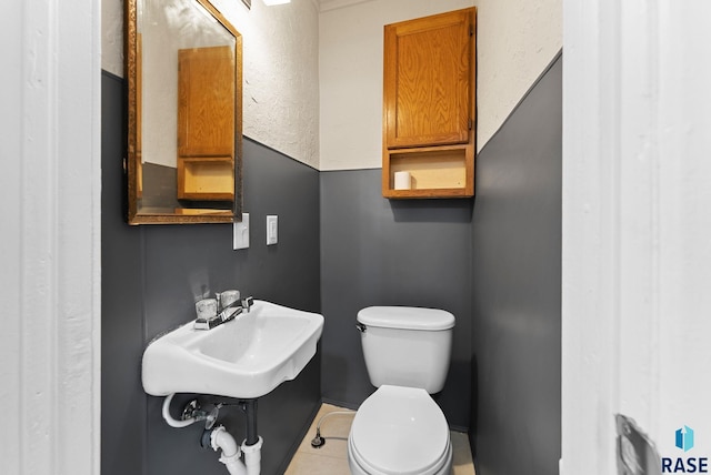 bathroom featuring tile patterned floors, toilet, and sink