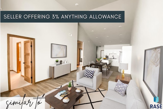 living room featuring high vaulted ceiling, light hardwood / wood-style flooring, and sink