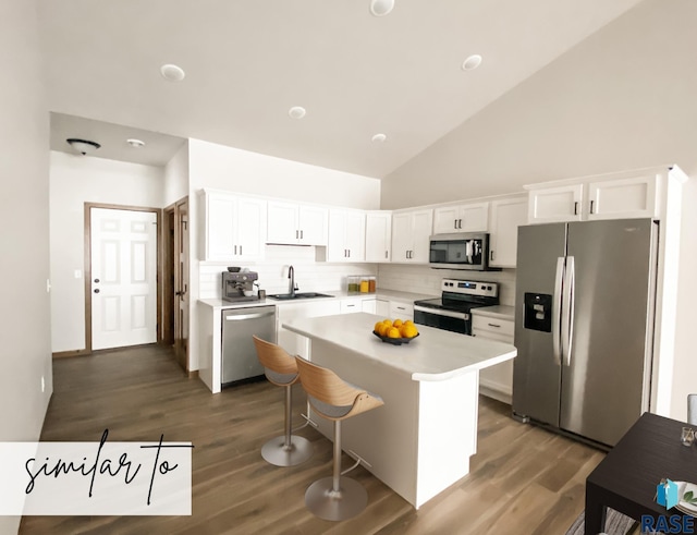 kitchen with a center island, high vaulted ceiling, tasteful backsplash, white cabinetry, and stainless steel appliances