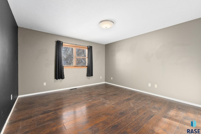 empty room with dark hardwood / wood-style floors