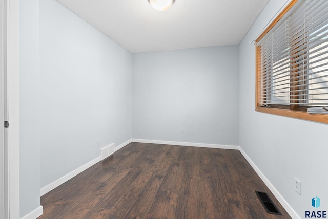 spare room with dark hardwood / wood-style flooring