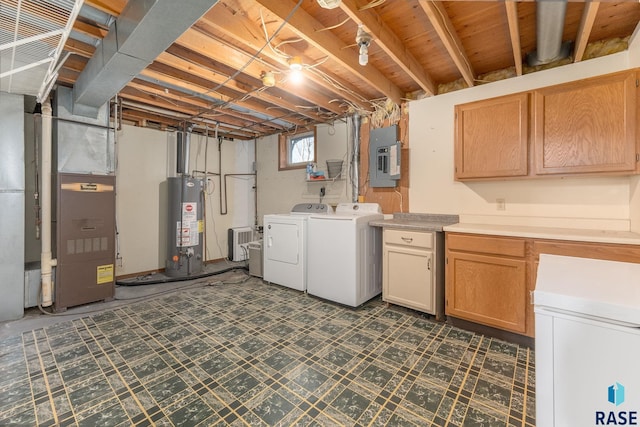 basement with electric panel, gas water heater, and washing machine and clothes dryer