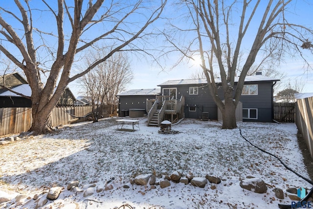 snow covered property with a wooden deck