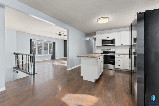 kitchen with dark hardwood / wood-style flooring, a center island, white cabinets, and appliances with stainless steel finishes