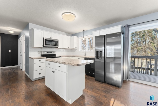 kitchen with white cabinetry, a center island, stainless steel appliances, dark hardwood / wood-style flooring, and pendant lighting