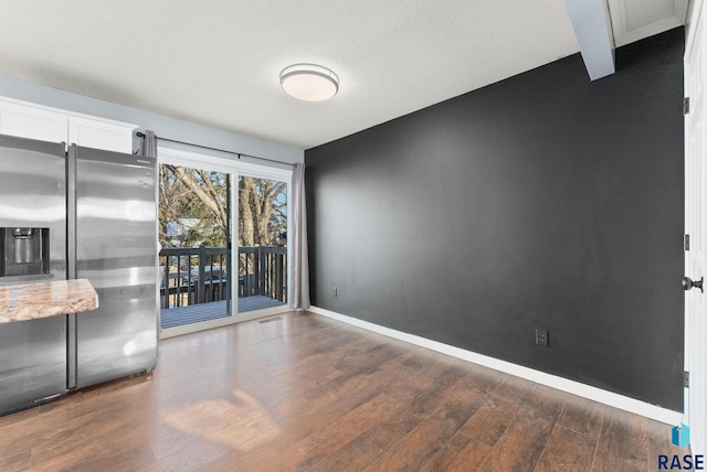 spare room with dark hardwood / wood-style flooring and a textured ceiling