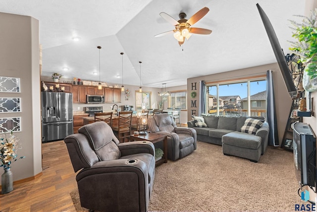 living room with hardwood / wood-style floors, vaulted ceiling, and ceiling fan