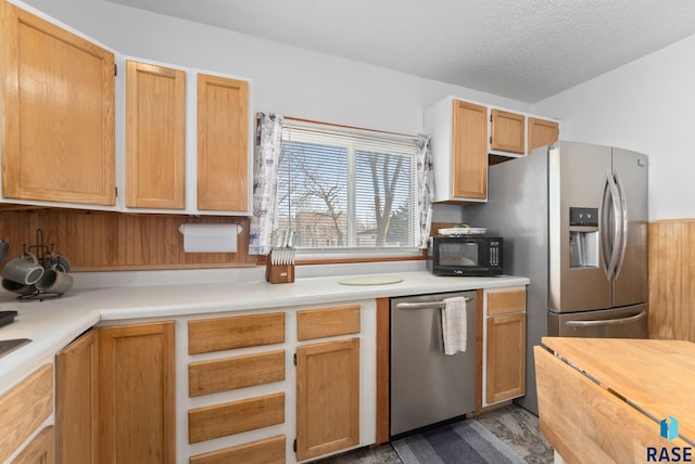 kitchen featuring wood-type flooring, a textured ceiling, and appliances with stainless steel finishes