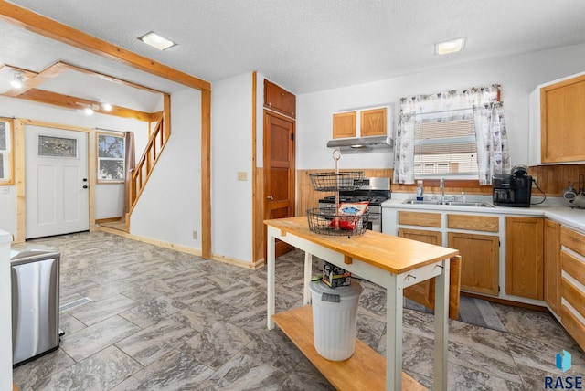 kitchen featuring a textured ceiling, gas stove, and sink