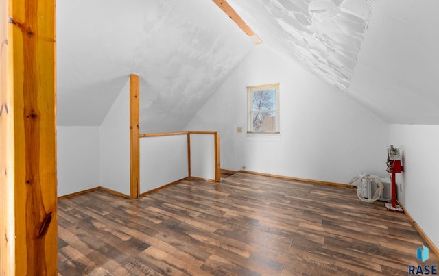 additional living space with dark hardwood / wood-style flooring and vaulted ceiling