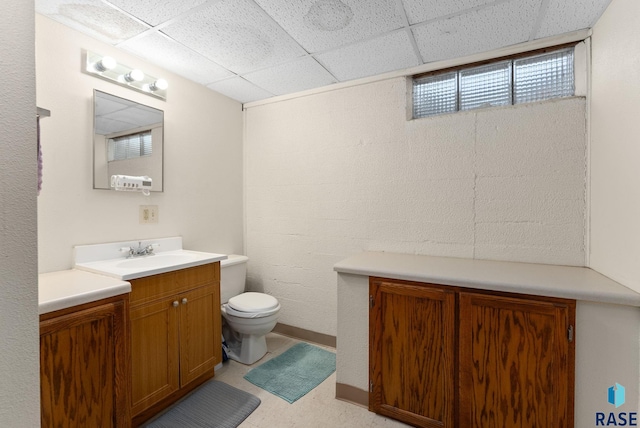 bathroom featuring a drop ceiling, vanity, and toilet