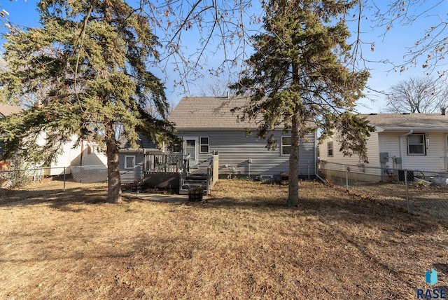 rear view of property with a yard and a wooden deck