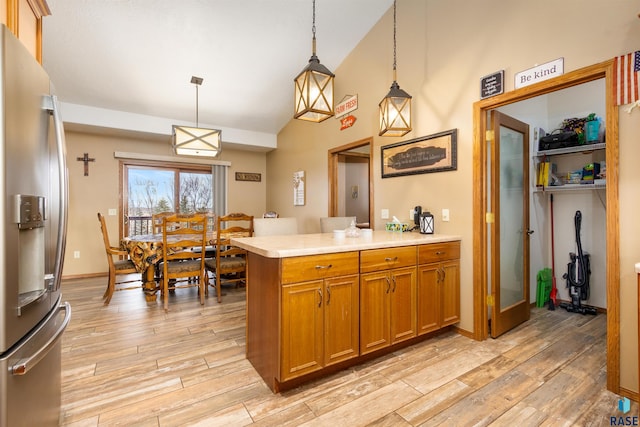 kitchen featuring kitchen peninsula, stainless steel refrigerator with ice dispenser, high vaulted ceiling, light hardwood / wood-style floors, and hanging light fixtures