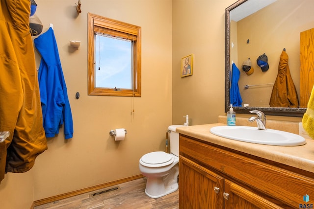 bathroom with hardwood / wood-style flooring, vanity, and toilet