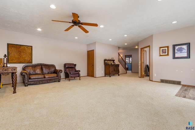 sitting room with light carpet, a textured ceiling, and ceiling fan