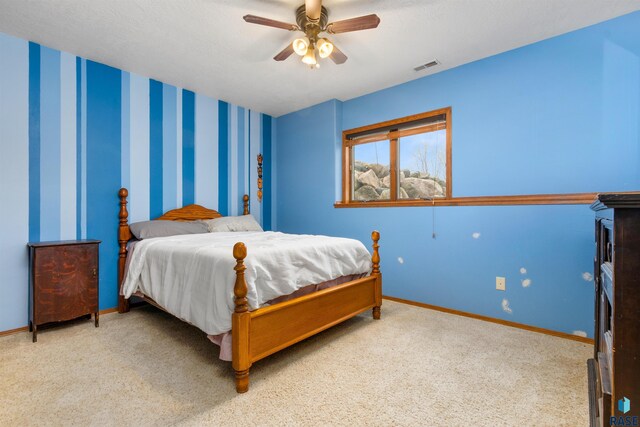 carpeted bedroom featuring ceiling fan and a textured ceiling