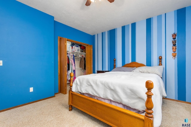 bedroom featuring ceiling fan, a closet, light carpet, and a textured ceiling