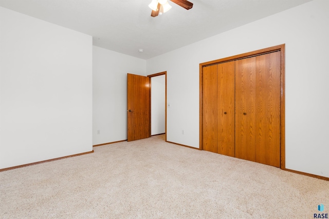 unfurnished bedroom with ceiling fan, a closet, and light carpet