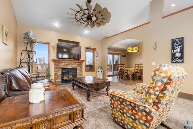 carpeted living room with a fireplace and ceiling fan