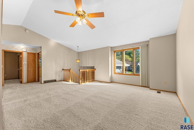 unfurnished living room featuring carpet flooring, ceiling fan, and vaulted ceiling