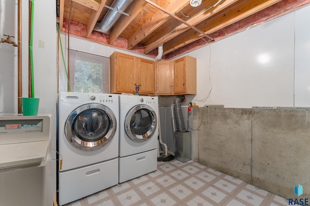 clothes washing area with cabinets and independent washer and dryer