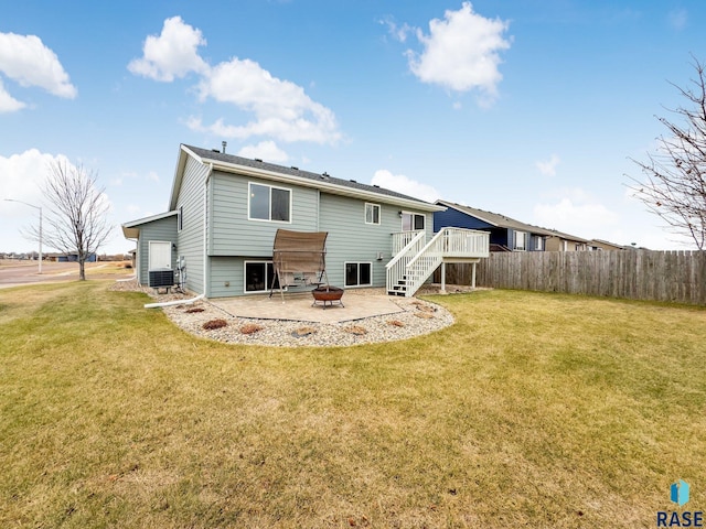 rear view of house with a yard, an outdoor fire pit, central AC, a wooden deck, and a patio