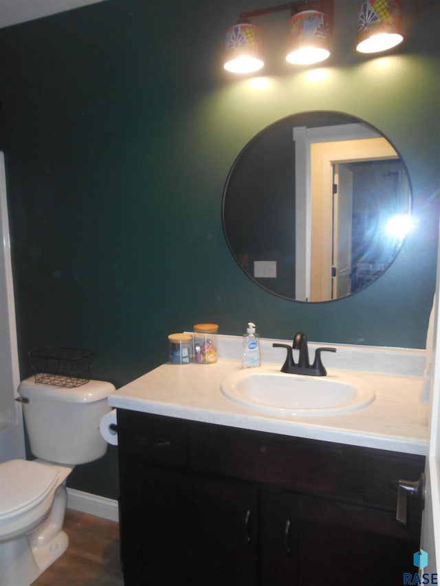 bathroom featuring vanity, hardwood / wood-style flooring, and toilet