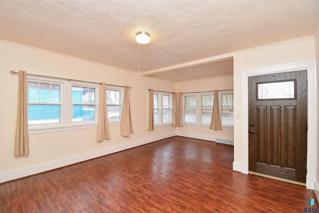 foyer with a textured ceiling and dark wood-type flooring