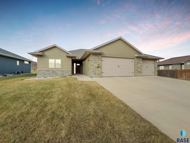 ranch-style home featuring a yard and a garage